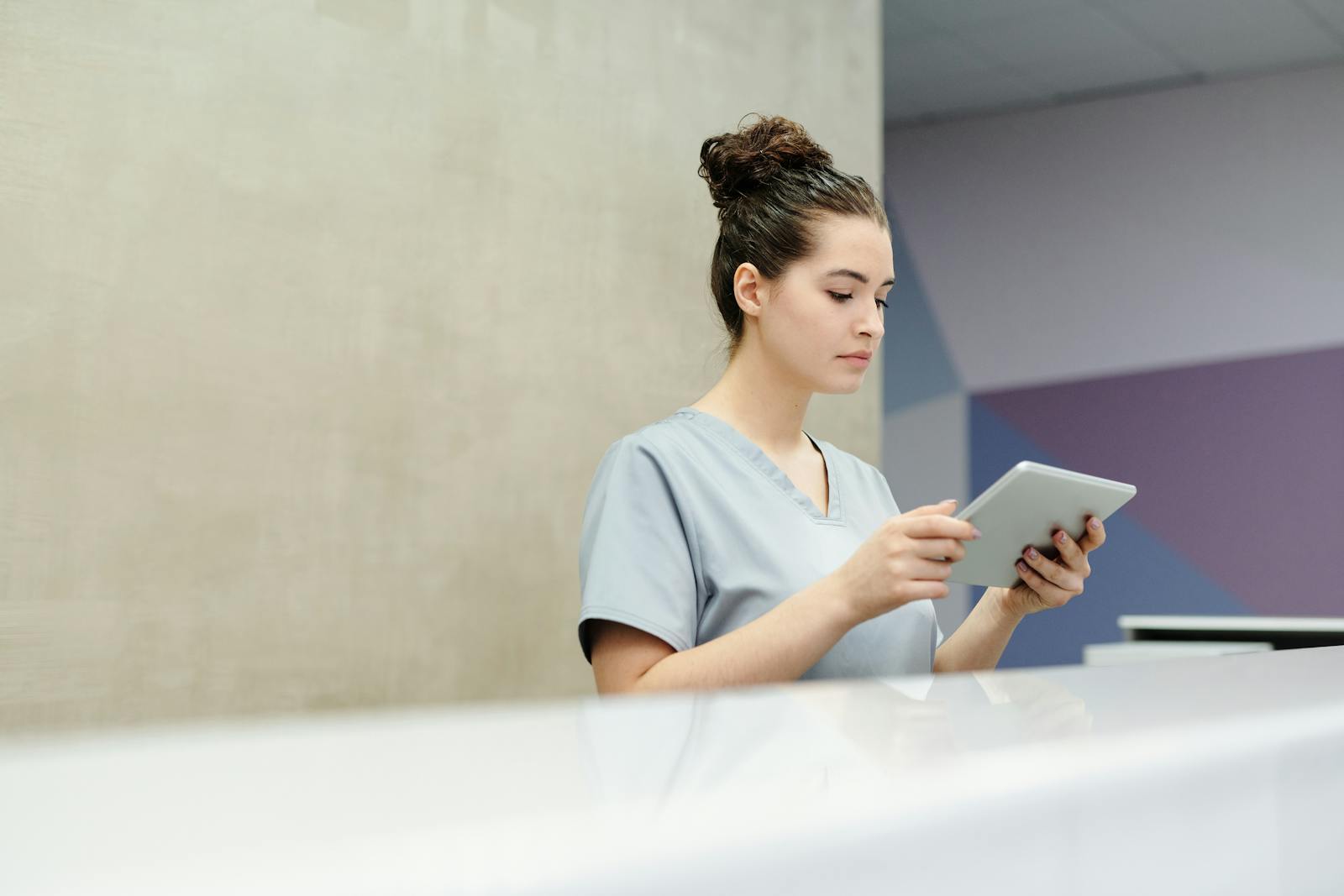 Clinic receptionist using a tablet
